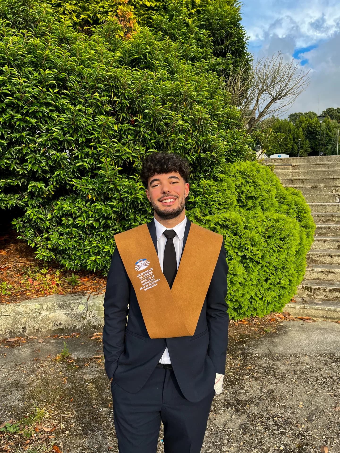 Raúl in a suit, wearing his graduation sash
